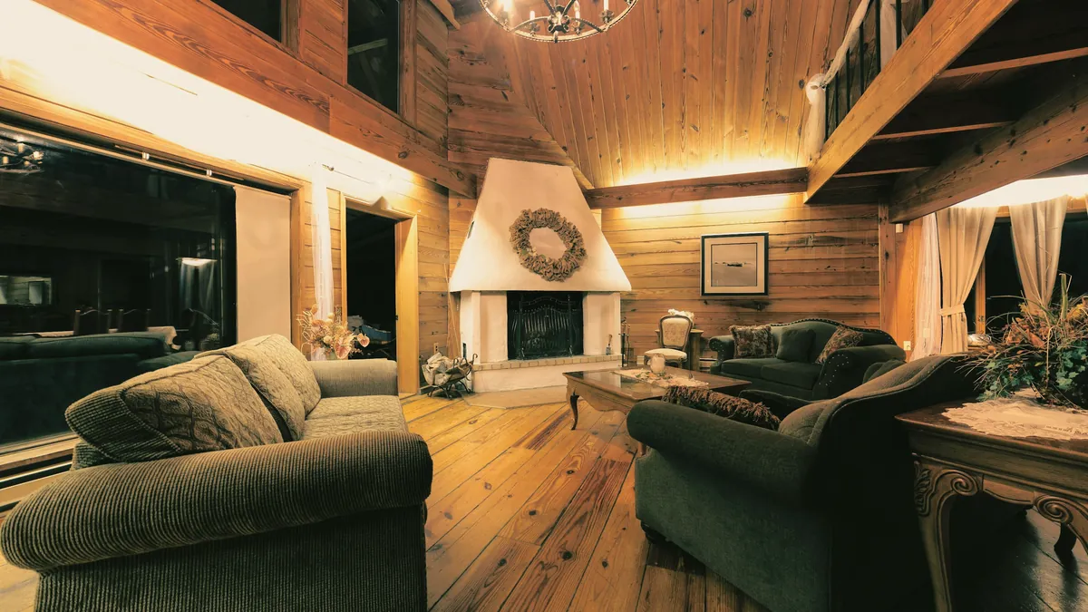 Lounge mit Kamin und großen Fenstern ins Grüne